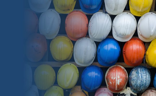 Rows of colorful hard hats displayed on a wall